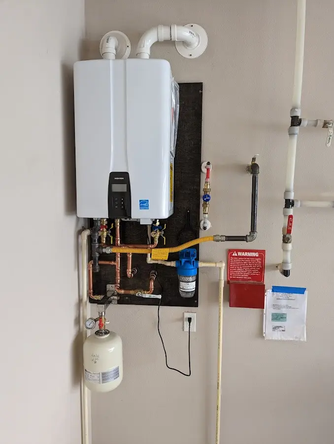 Professional plumber installing copper piping in a Green Forest home